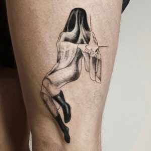 Surrealistisches Black & Grey Fine Line Tattoo einer sitzenden weiblichen Figur mit abstraktem, maskenartigem Kopf, gestochen von Jona bei Balaklava Tattoo Münster. Surreal black and grey fine line tattoo of a seated female figure with abstract mask-like head, tattooed by Jona at Balaklava Tattoo Münster.