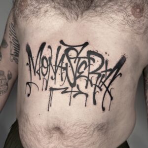 Großflächiges Graffiti Schriftzug Tattoo Monasteria in Blackwork auf der Brust, gestochen von Thorben bei Balaklava Tattoo Münster Large scale graffiti lettering tattoo Monasteria in blackwork on the chest, tattooed by Thorben at Balaklava Tattoo Münster
